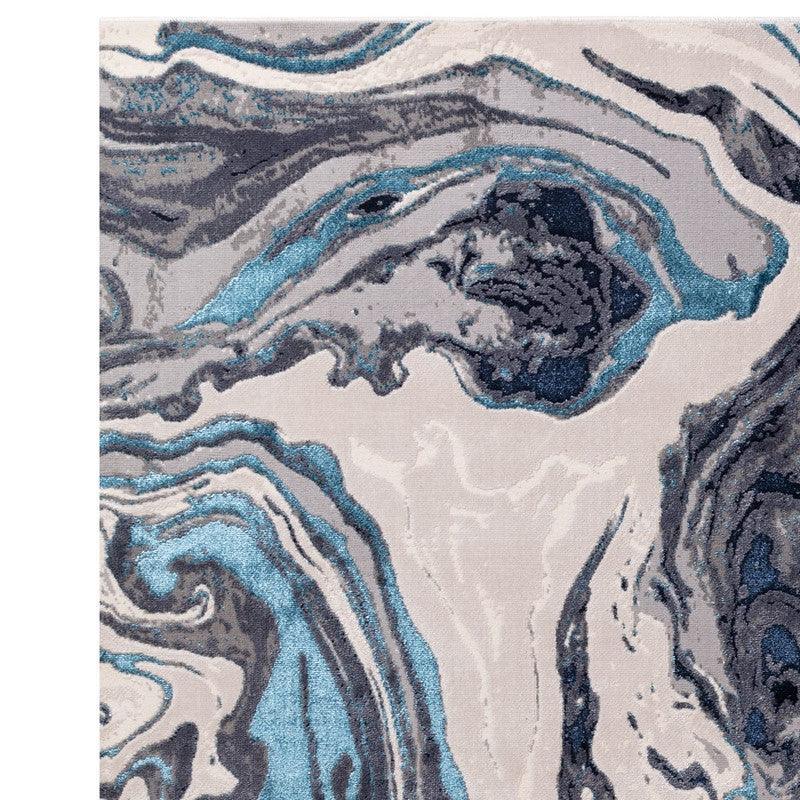 Abstract area rug with blue, grey and cream marble pattern, close-up texture view