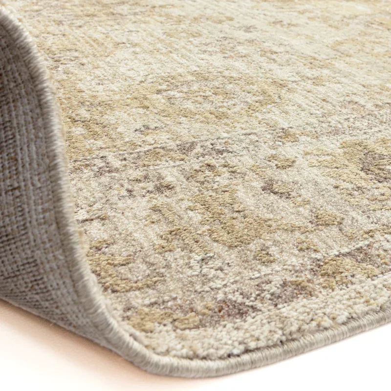 Beige patterned area rug with textured pile, close side view showing woven edge