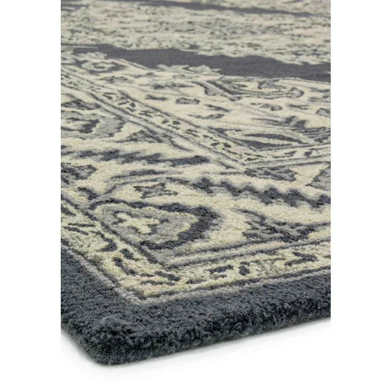 Close up of grey and cream patterned rug with thick pile and ornate border detail