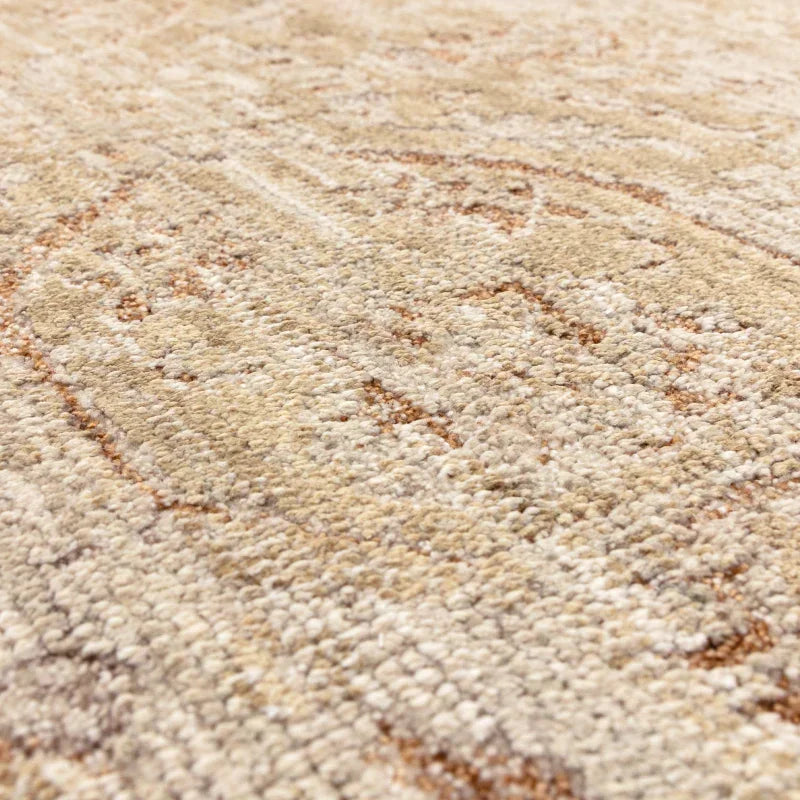 Close up of beige patterned area rug with textured pile and subtle geometric design
