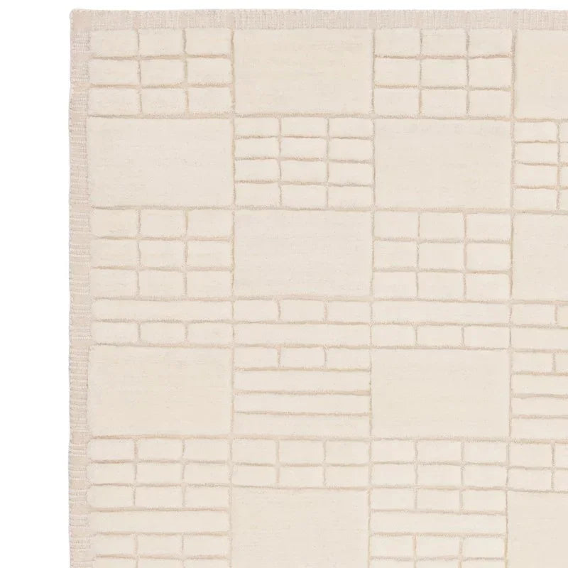 Cream area rug with geometric block pattern and subtle textured squares