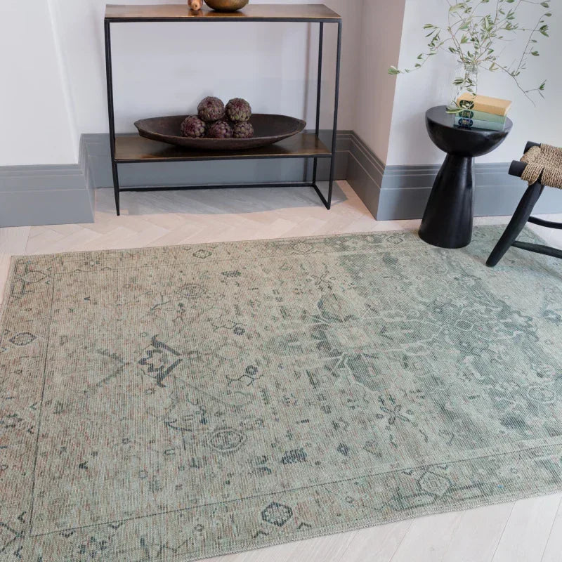 Green patterned area rug on light wood floor in modern living room