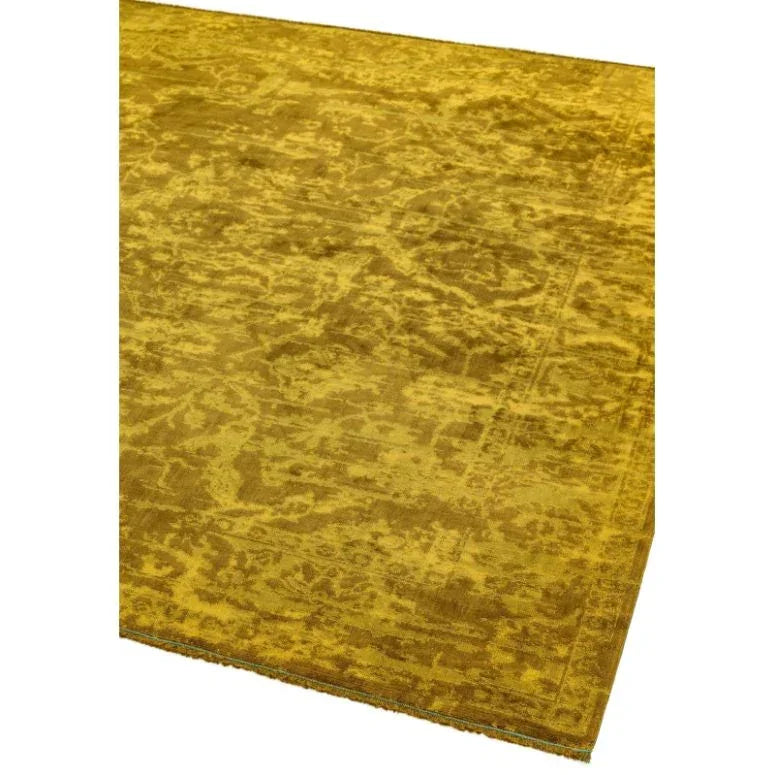 Golden yellow area rug with subtle distressed pattern, shown from an angled corner view