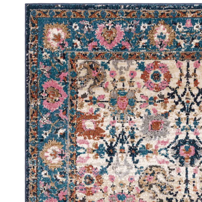 Traditional area rug with floral pattern in teal, pink, ivory and brown, close-up corner view