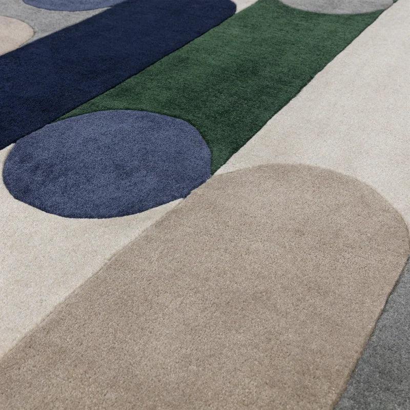 modern area rug with geometric shapes in beige, blue, green, and grey tones