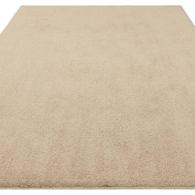 Beige shaggy area rug with soft pile and plain texture shown from above