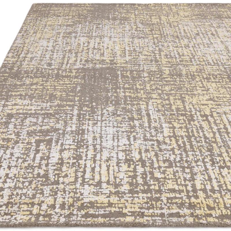 Abstract beige and cream area rug with textured modern pattern, viewed from side angle