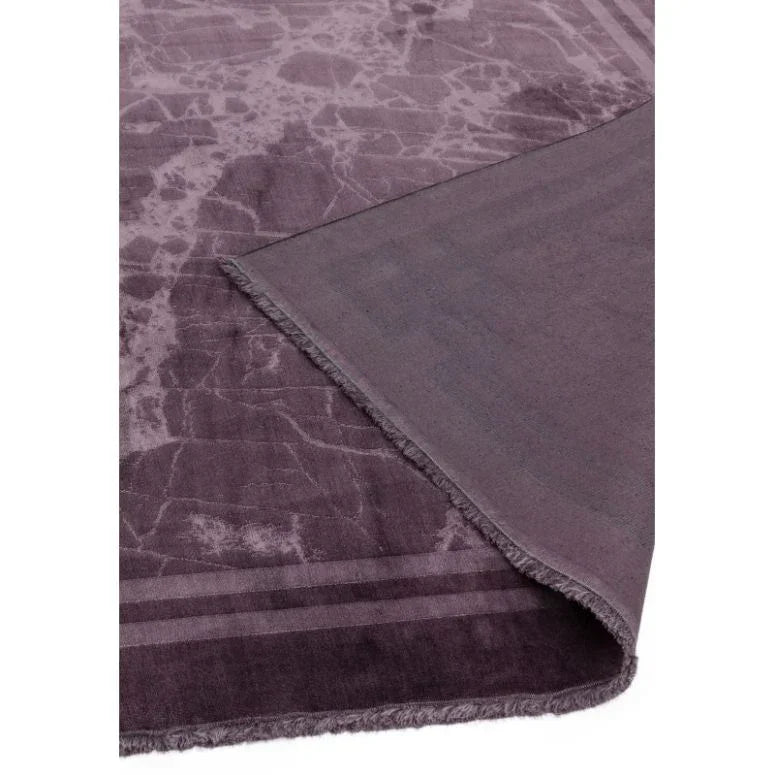 Purple marble effect rug with visible corner fold and subtle textured border