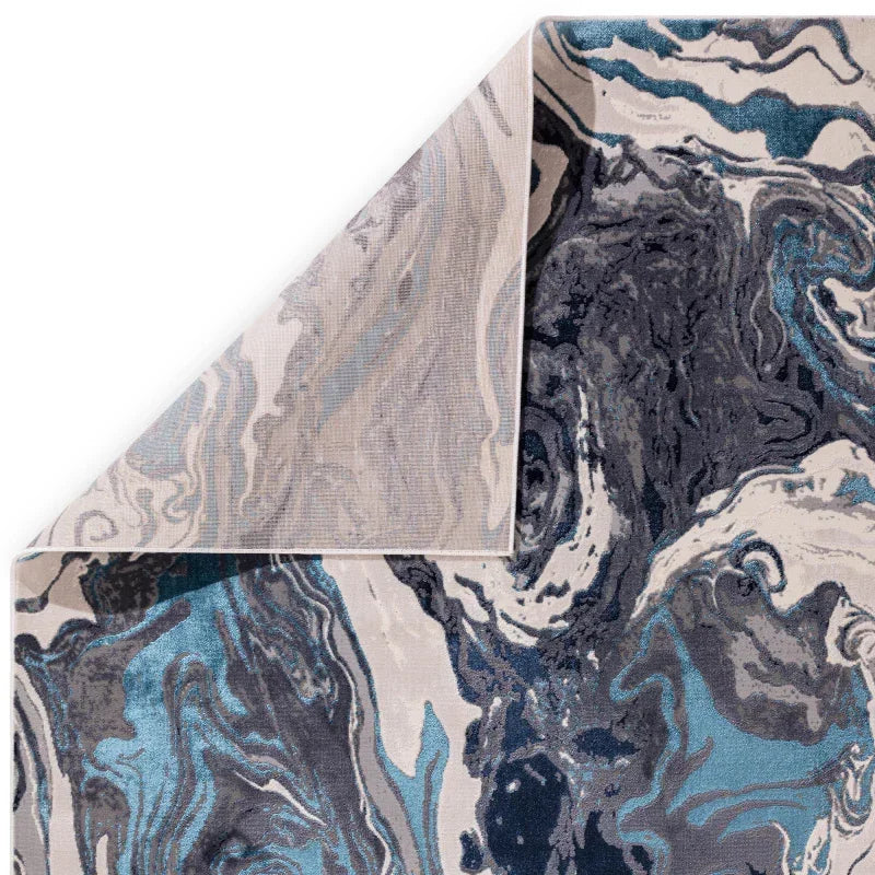 Abstract blue and grey area rug with marbled pattern, corner folded to show backing