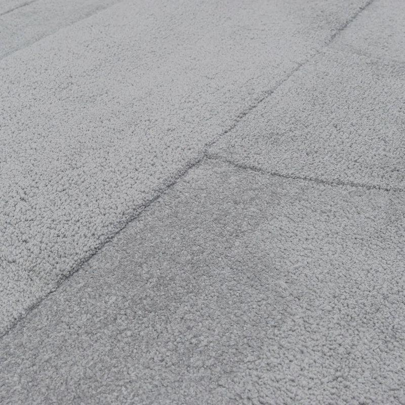 Close-up grey textured rug with soft pile and subtle geometric pattern
