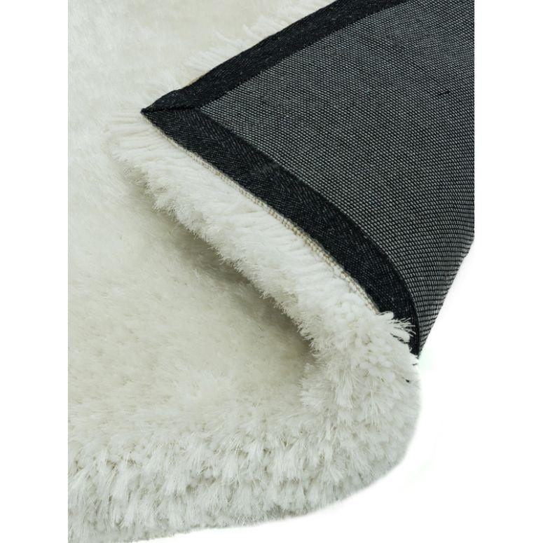 White shaggy rug with textured pile and non-slip black backing, corner folded over