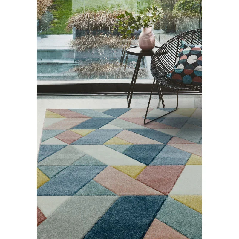 Geometric patterned rug with pastel blue, pink, yellow and grey shapes in modern living room