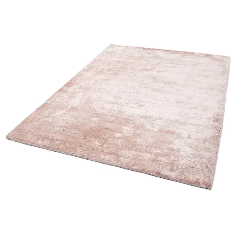 Blush pink rectangular area rug with soft texture shown from angled view