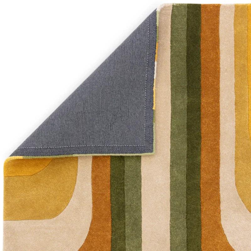 Modern area rug with green, mustard, and beige geometric stripes, corner flipped to show backing