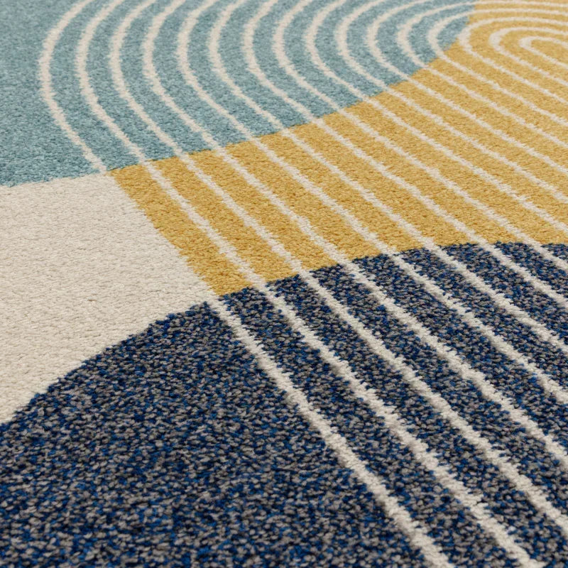 Modern area rug with curved blue, yellow, and white geometric patterns and textured fibers