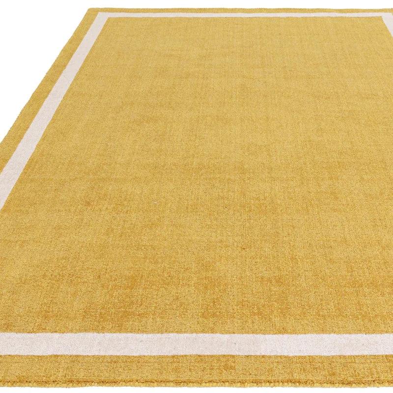 Yellow area rug with white border detail viewed from above
