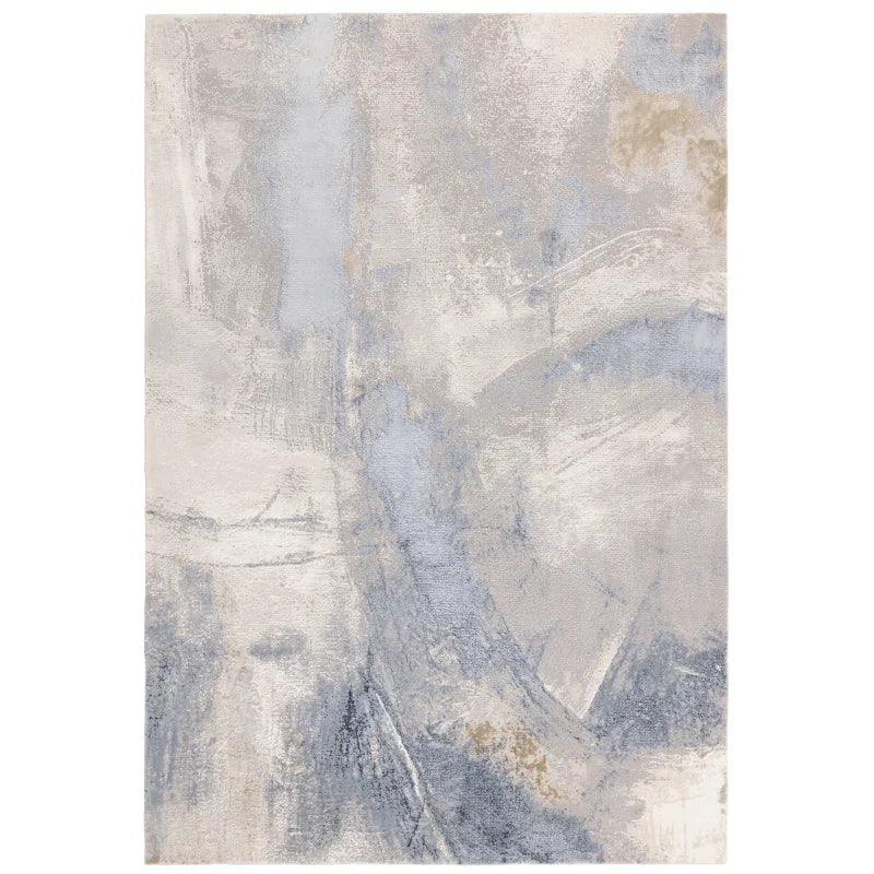 Abstract area rug with soft blue, beige, and grey tones and textured design