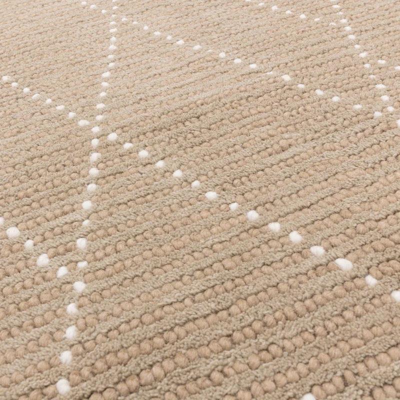 Beige textured wool rug with white dotted diamond pattern, close-up of woven detail