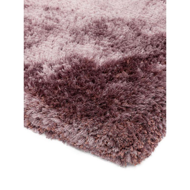 Close-up of thick purple shaggy rug corner with soft textured pile