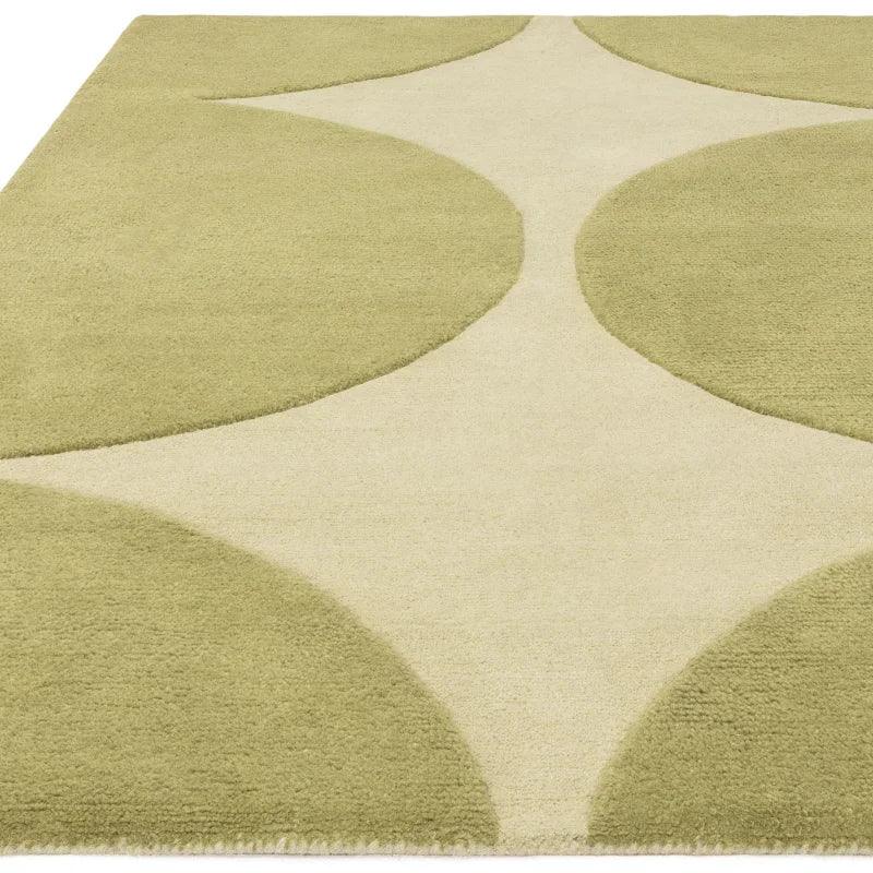 Green and cream area rug with abstract geometric pattern, close-up angle