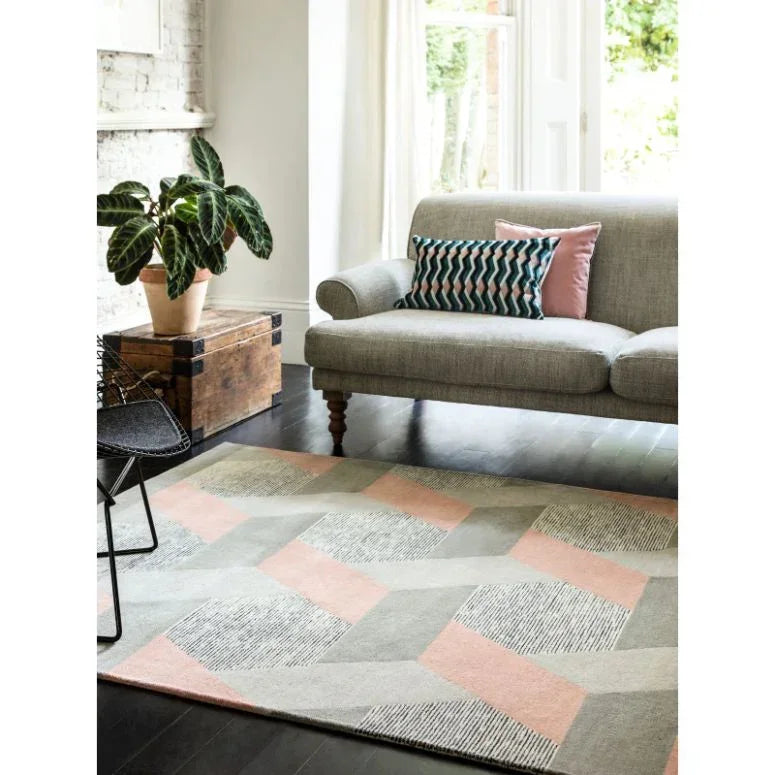 Geometric patterned area rug with grey and blush pink tones in modern living room setting