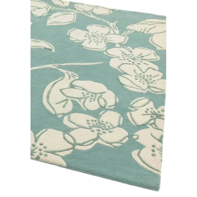 Blue floral patterned rug with cream flower design, corner view showing texture detail