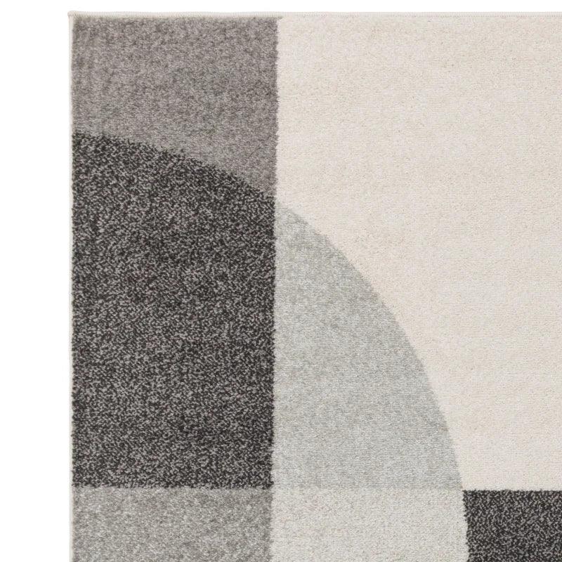 Grey and cream geometric patterned rug close-up showing soft textured material