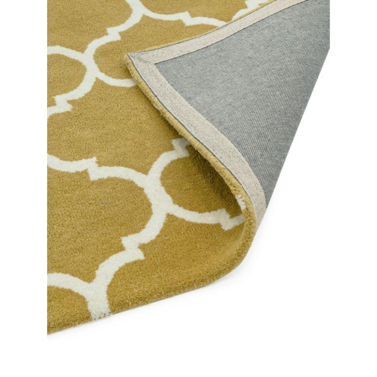 gold patterned area rug with white lattice design and exposed woven backing corner