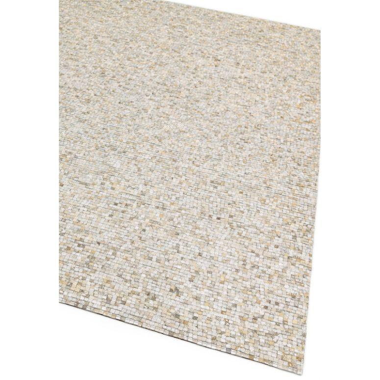 Beige woven area rug with mosaic pattern and textured surface, close-up corner view