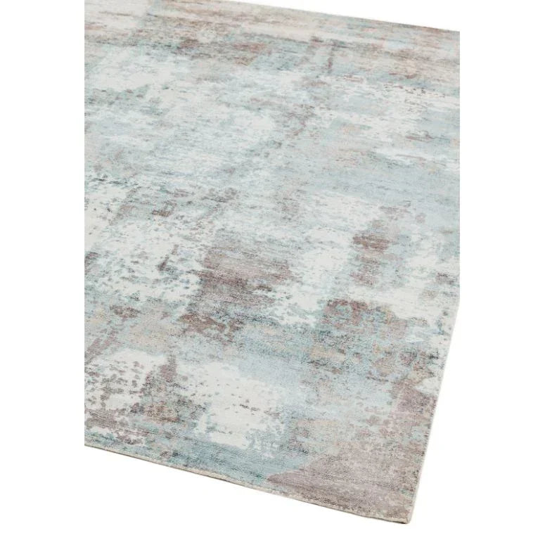 Abstract pattern area rug in soft blue and beige tones, corner view