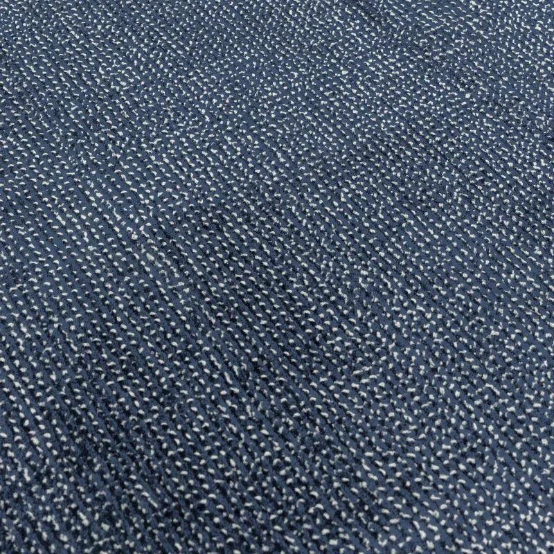 Textured blue rug surface with woven fabric detail shown close up