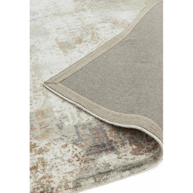 Neutral abstract area rug with soft distressed pattern, focus on corner and backing detail