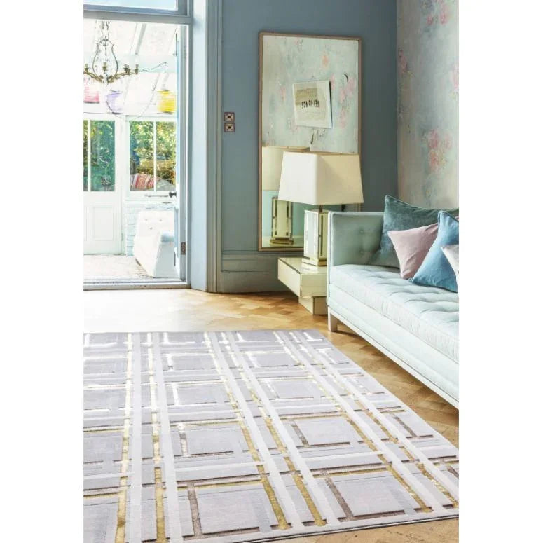 Modern geometric area rug with gold accents in blue living room with sofa and mirror