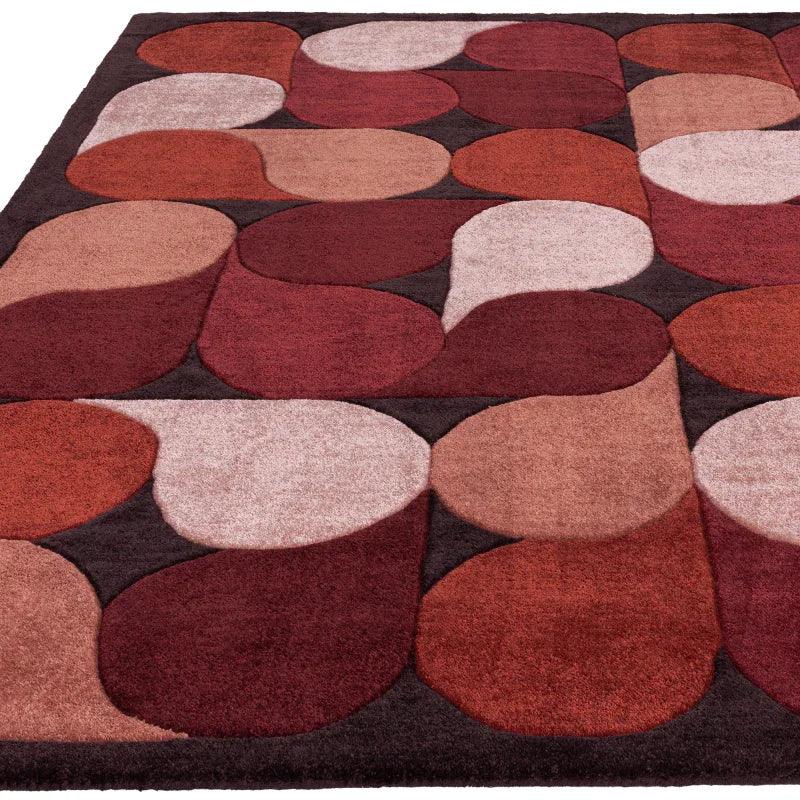 Geometric patterned area rug in red, orange, beige and brown tones with textured finish