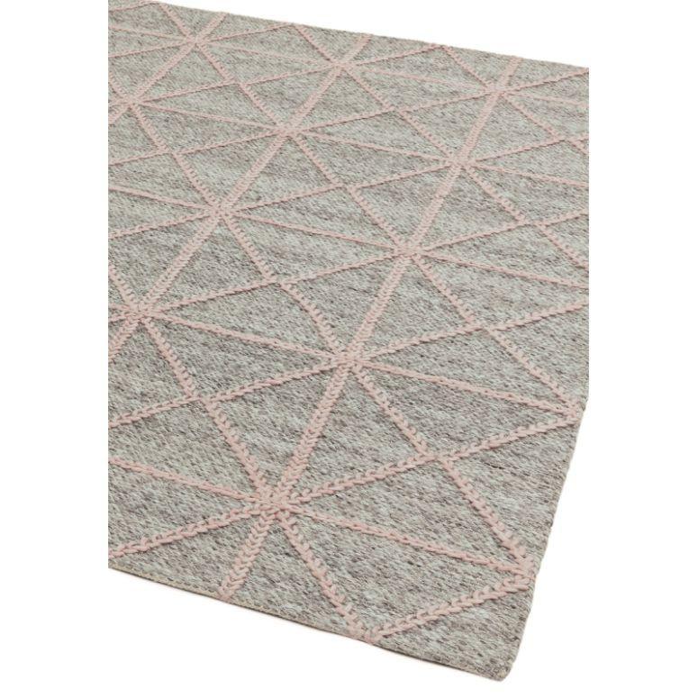 Grey area rug with pink geometric diamond pattern and textured finish