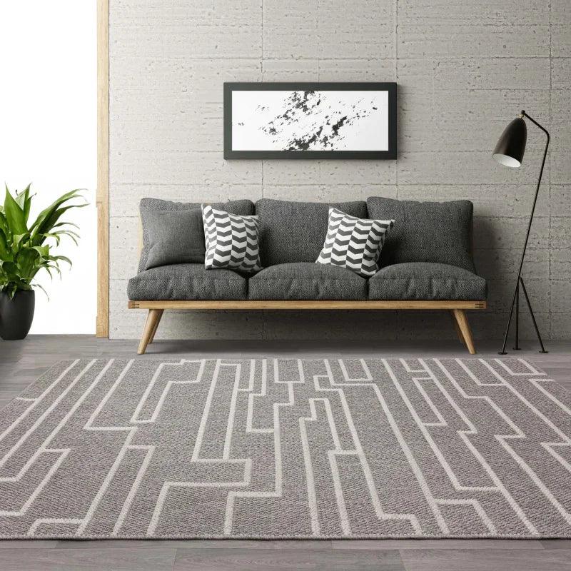 Grey patterned rug in modern living room with grey sofa and abstract wall art