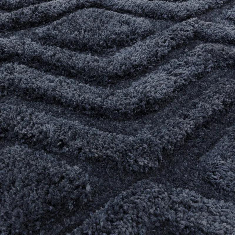 Charcoal grey textured rug closeup with raised zigzag pattern and soft pile