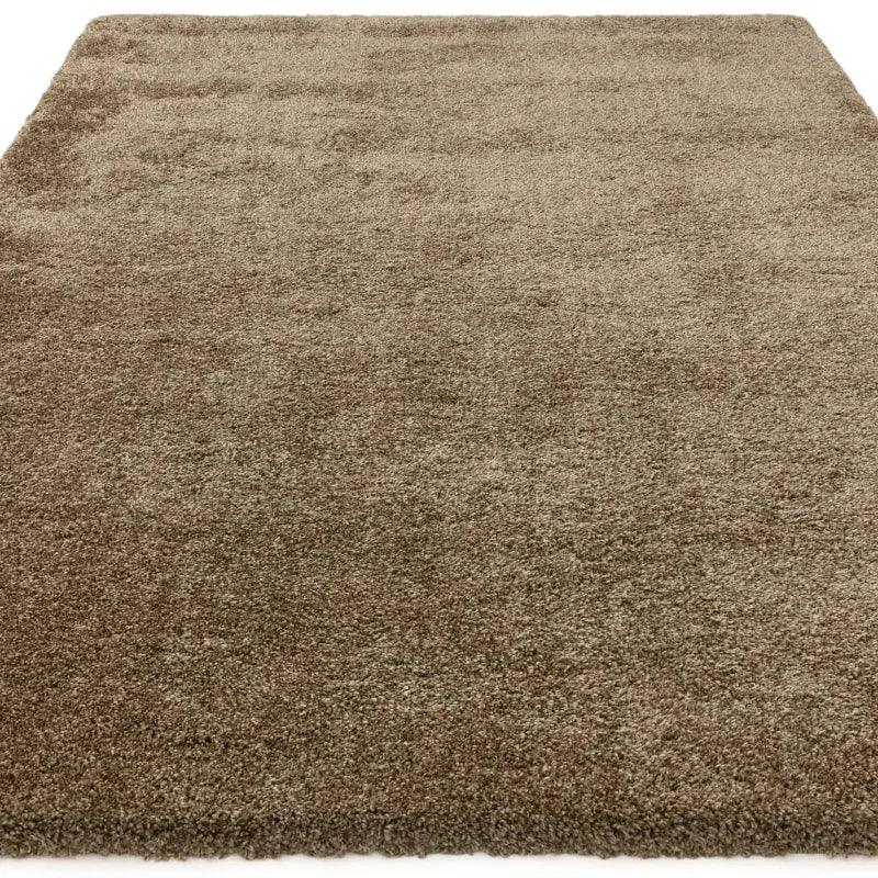 Rectangular beige shaggy rug with soft pile texture, shown from a low angled view