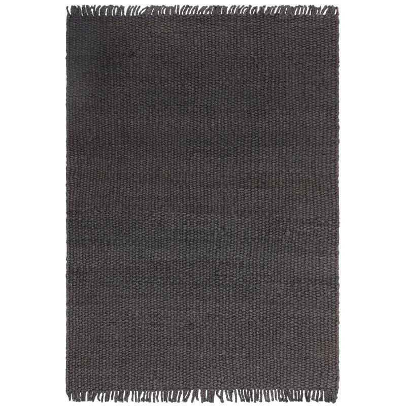 Charcoal woven rug with textured surface and fringe edge detailing