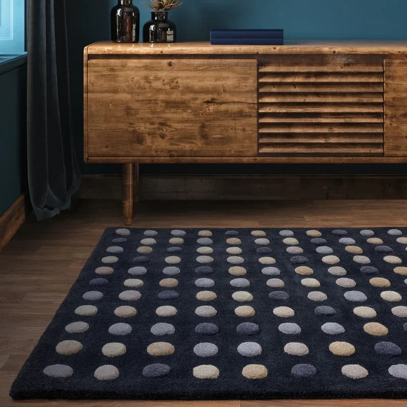 Dark blue polka dot rug on wooden floor in front of mid-century sideboard