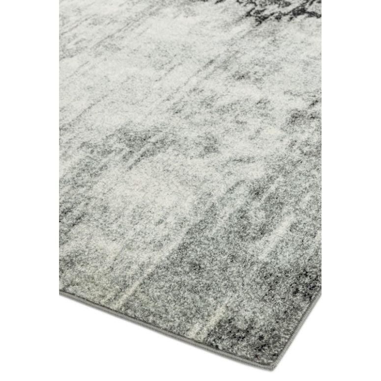 Grey and white area rug with abstract pattern, close view of textured corner