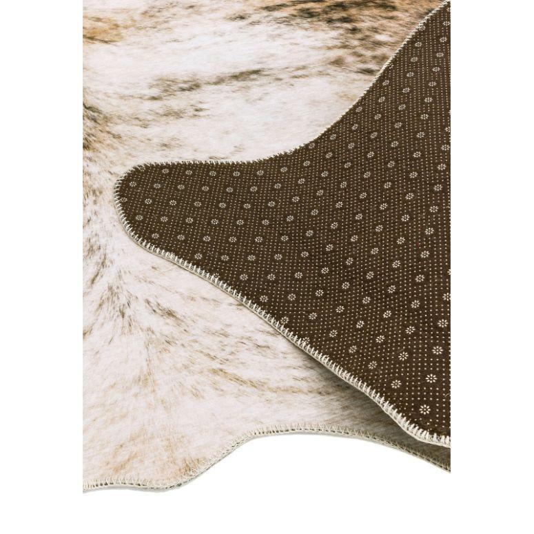 Faux cowhide rug with non-slip brown backing and beige speckled pattern
