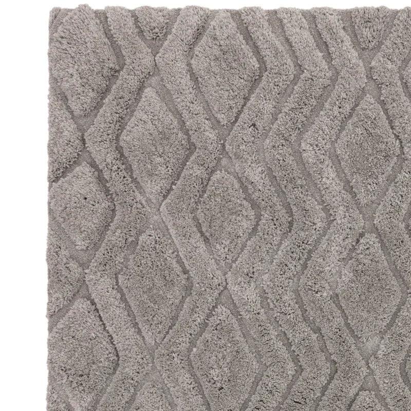 Grey patterned shaggy rug with geometric diamond design, close-up of textured surface