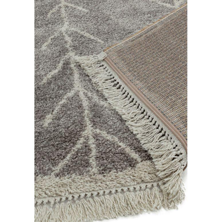 Grey patterned rug with white fringe and textured geometric lines, corner detail visible