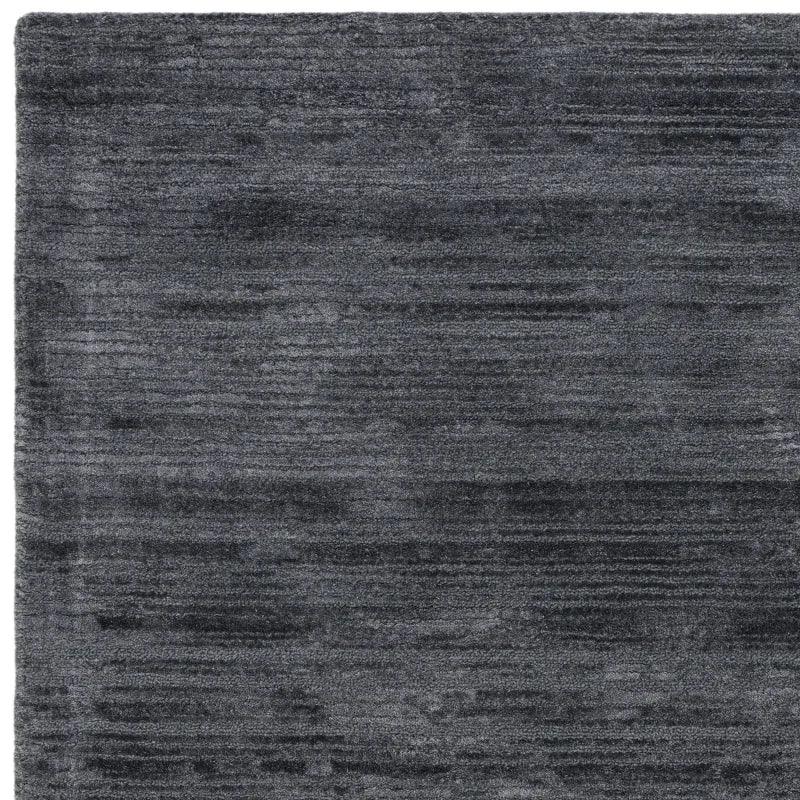 Dark grey rectangular area rug with subtle textured pattern and soft pile