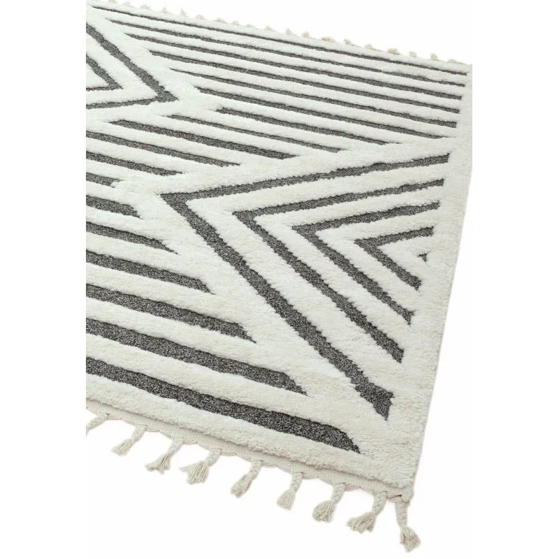 cream and grey geometric rug with chevron pattern and tassel fringe corner view