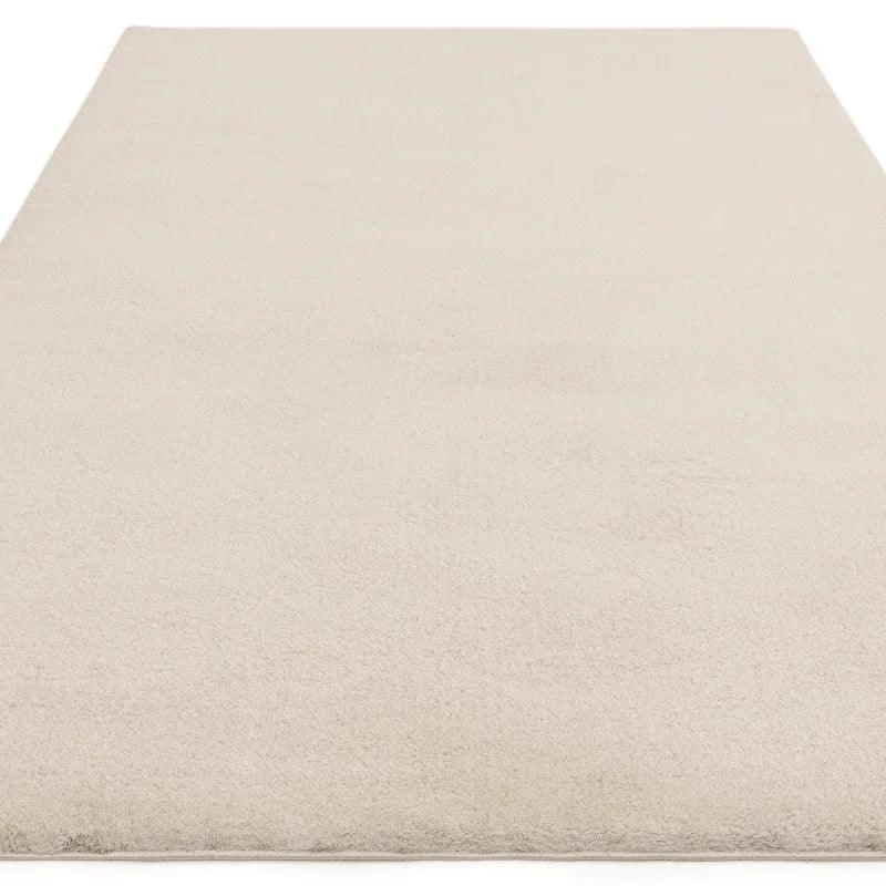 Ivory area rug with soft pile and minimal design shown from above