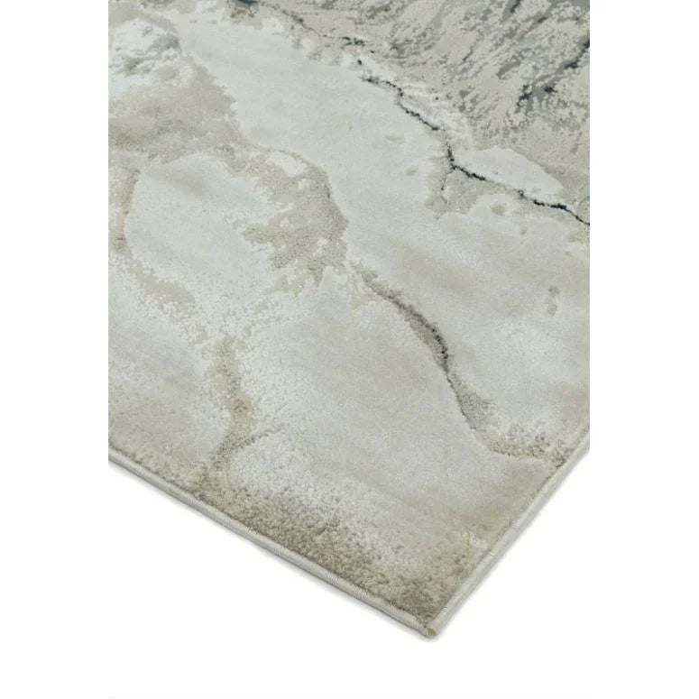 Beige area rug with abstract marble pattern and soft textured surface, corner view