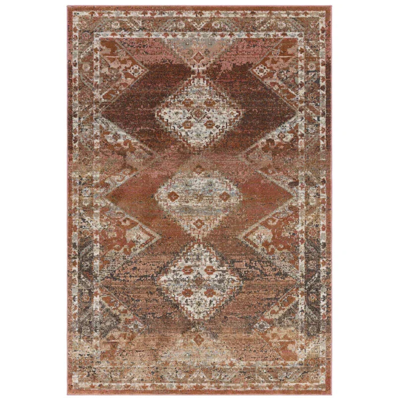 Rust and beige patterned area rug with geometric diamond design and distressed finish
