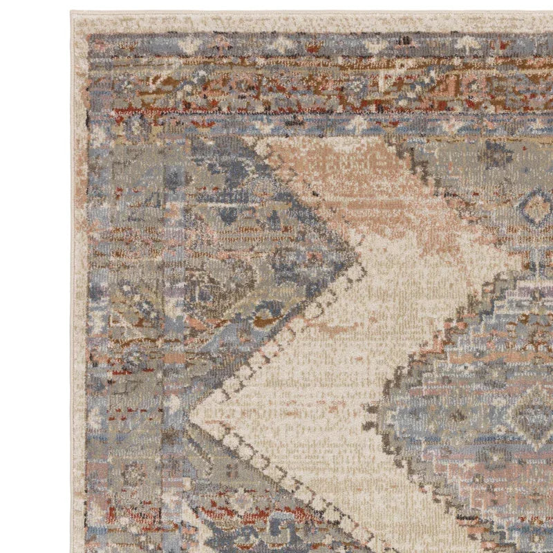 Patterned area rug with blue, beige, and terracotta geometric and floral designs, corner view